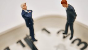 Two Miniature Business Figures Stand On A Clock Face, Symbolizing Time Management And Business Strategy In A Detailed Studio Close-up Shot. - Powered by Shutterstock - Get 15% off with code: PIKWIZARD15