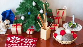 Merry Christmas and Happy New Year! Let's get ready for winter holidays, decorate tabletop Christmas tree, knitting warm scarf with traditional snowflake pattern as gifts. Knitting accessories nearby - Powered by Shutterstock - Get 15% off with code: PIKWIZARD15
