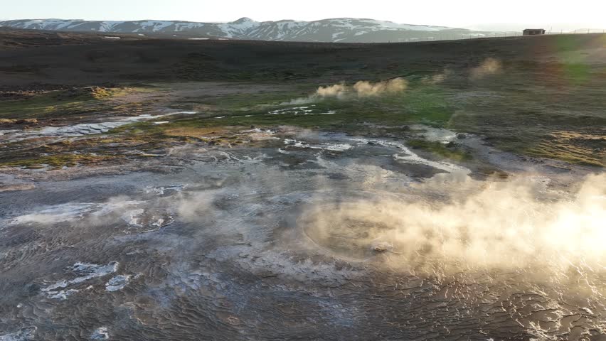 Aerial view of a geothermal area where steam rises from the earth in a contrasting landscape, creating a surreal scene, iceland.