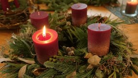 Lit Advent wreath with red candles and pinecones on rustic wooden table - Powered by Shutterstock - Get 15% off with code: PIKWIZARD15