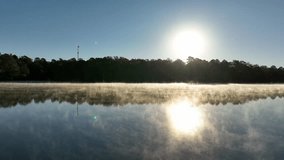Sunrise light shines through thick steam fog as mist rises above a calm lake surface. - Powered by Shutterstock - Get 15% off with code: PIKWIZARD15