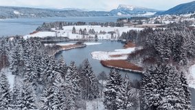 Aerial view of the snow-covered landscape around Lac de Joux contrasting with the dark water and the snow-dusted trees, Tete du Lac, Vallee de Joux, Switzerland. - Powered by Shutterstock - Get 15% off with code: PIKWIZARD15