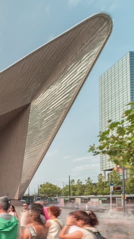 Hyperlapse of Rotterdam Central Station, the main railway hub in South Holland, Netherlands. Modern architecture with skyscrapers in the background and busy people on the square timelapse