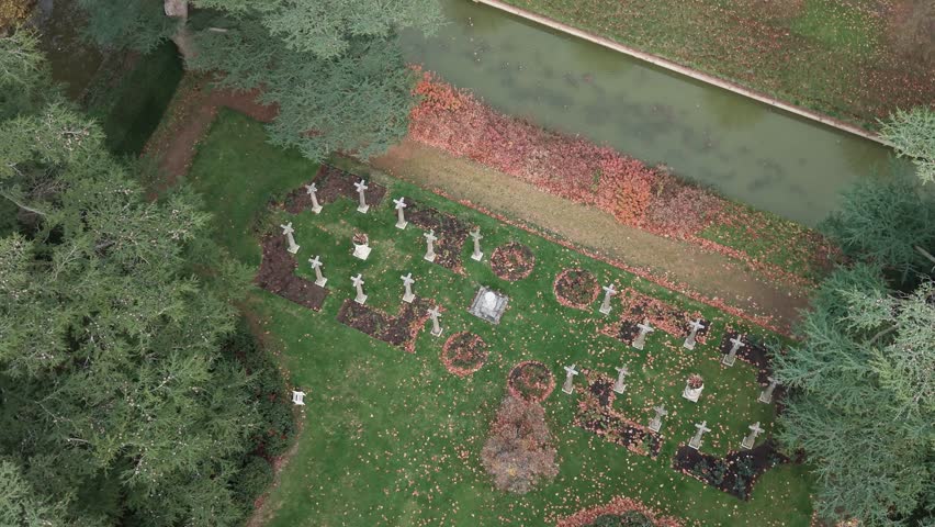 Kentwell hall mansion estate graveyard and moat covered in fallen Autumn leaves aerial view