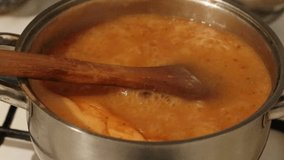 Wooden spoon and boiling soup in a metal pot. - Powered by Shutterstock - Get 15% off with code: PIKWIZARD15