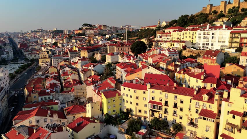Lisbon at Sunset from Above – Drone View of Historic Rooftops, Red Palm Trees, Ocean Atmosphere and Timeless City Square