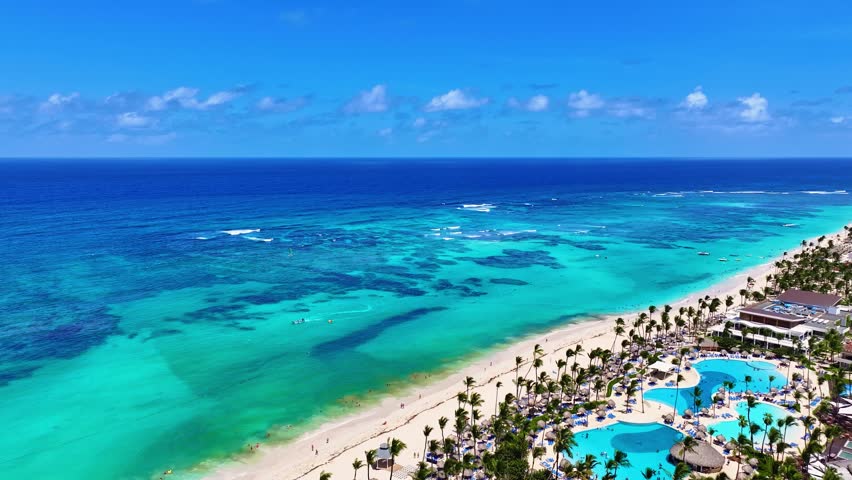 Beautiful drone view of a Caribbean palm beach. Luxury resorts and tourist destinations. Summer vacation by the sea. Bavaro Beach, Punta Cana, Dominican Republic. Aerial seascape.