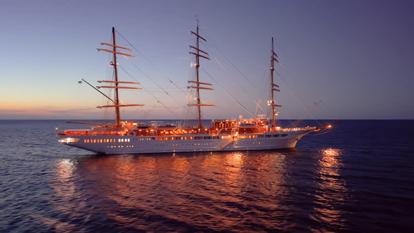 sunset ship glow, tranquil sunset voyage aboard grand threemasted vessel with reflective waters. Calvi. Corsica. France