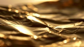 Dynamic golden abstract background featuring shimmering light reflections on crumpled foil. Perfect for luxury, festive, or elegant video projects and presentations. - Powered by Shutterstock - Get 15% off with code: PIKWIZARD15