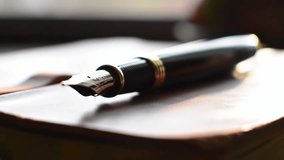 Cinematic close-up of an elegant fountain pen on a leather notebook, featuring a smooth focus transition. Ideal for professional writing, luxury stationery, or creative inspiration. - Powered by Shutterstock - Get 15% off with code: PIKWIZARD15