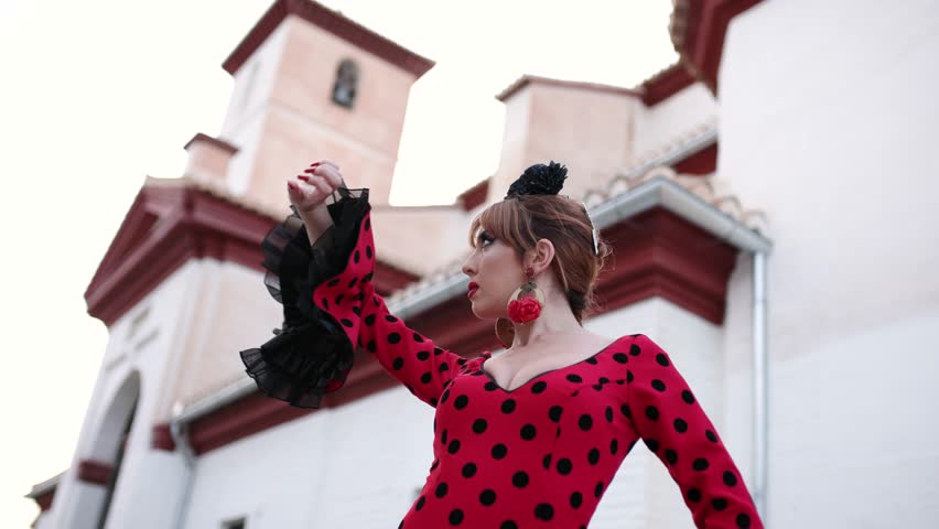 Graceful female flamenco dancer performing traditional spanish dance outdoors. The passionate woman expresses emotion through her hand movements