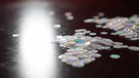 Dynamic close-up of iridescent glitter particles shimmering with rainbow reflections on a dark surface. Perfect for festive events, luxury, or abstract overlays. - Powered by Shutterstock - Get 15% off with code: PIKWIZARD15
