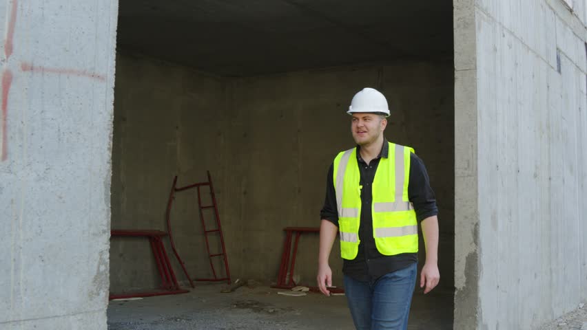 construction worker is standing inside an unfinished concrete building structure