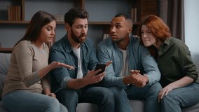 Four multiracial friends at home party looking in mobile phone lost bet casino failure confused sad diversity multiethnic people men women watching sport game streaming on smartphone bad result shock - Powered by Shutterstock - Get 15% off with code: PIKWIZARD15