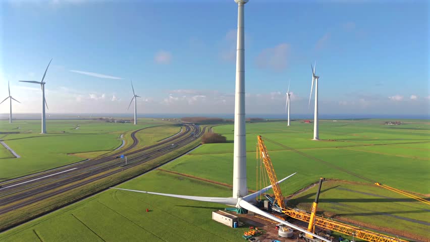 Drone Video of Wind Turbine Under Construction with Crane Hoisting Rotor Assembly