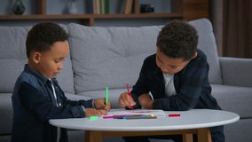Two ethnic African American boys drawing communicate enjoying draw picture kids pupils sons siblings at home family children brothers together talking busy with art therapy homework studying artwork - Powered by Shutterstock - Get 15% off with code: PIKWIZARD15