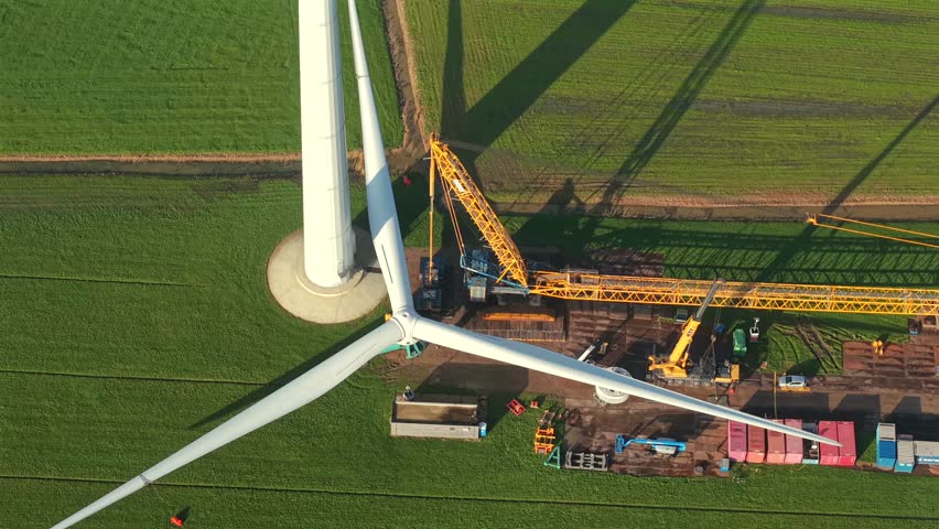 Drone Video of Wind Turbine Under Construction with Crane Hoisting Rotor Assembly
