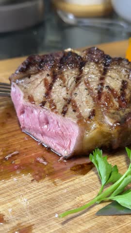 pour dark sauce over steak Freshly cooked delicious juicy tuna steak on a plate with a slice of lemon.