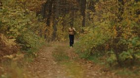 Young man wearing cap and sunglasses runs in an autumn forest with chest heart rate monitor and and watches indicators pulse by looking at monitor in his hand to control intensity of his workout - Powered by Shutterstock - Get 15% off with code: PIKWIZARD15