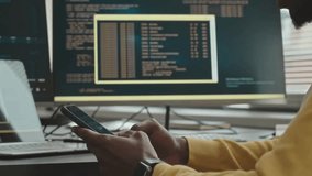 A programmer multitasks between coding and checking his smartphone, showing the modern digital work style.
 - Powered by Shutterstock - Get 15% off with code: PIKWIZARD15