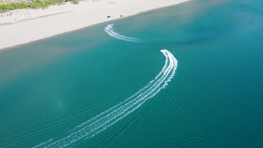 Tourists rides a jet ski. Tourist on personal watercraft, aerial drone view. People having fun on the sea. Jet water scooter on the sea. PWC.