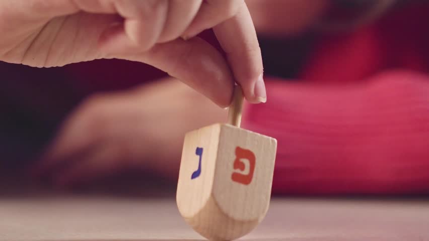 A detailed 4K view of a dreidel, the four-sided spinning top used for a traditional Jewish game during the Hanukkah holiday. - Powered by Shutterstock - Get 15% off with code: PIKWIZARD15