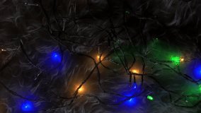 Colorful LED string lights glowing softly in the dark, forming scattered patterns across a wooden surface. Warm and cool tones blend gently, creating a festive and vibrant looping background. - Powered by Shutterstock - Get 15% off with code: PIKWIZARD15
