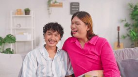 Portrait of transgender woman and partner showing heart gesture in house. Attractive loving LGBTQ couple spending free leisure time together, dating and looking at camera in cozy living room at home. - Powered by Shutterstock - Get 15% off with code: PIKWIZARD15