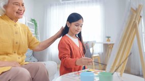 Asian loving grandmother support granddaughter with drawing at home. Caring elderly senior grandma encourage little girl�s creativity, enjoying fun and educational art activity together in living room - Powered by Shutterstock - Get 15% off with code: PIKWIZARD15