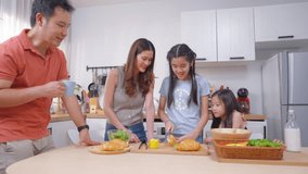 Asian parents bake bakery with their young daughters in kitchen at home. Happy family enjoy preparing healthy food together as mom and dad teach their little girls make breakfast in loving atmosphere. - Powered by Shutterstock - Get 15% off with code: PIKWIZARD15