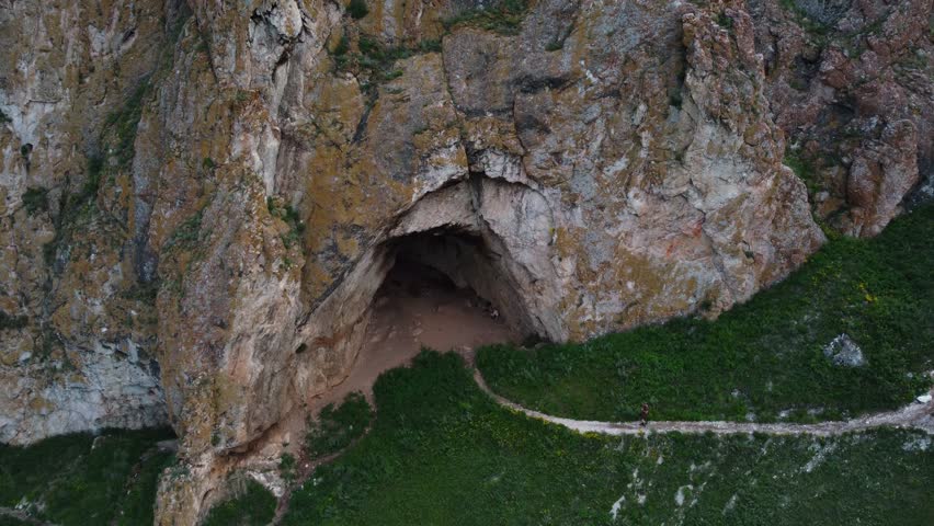 Entrance to a cave in the rock. A large grotto. View from a drone.