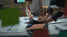 Anonymous business colleagues brainstorming and reviewing financial documents with charts on a tablet - Powered by Shutterstock - Get 15% off with code: PIKWIZARD15