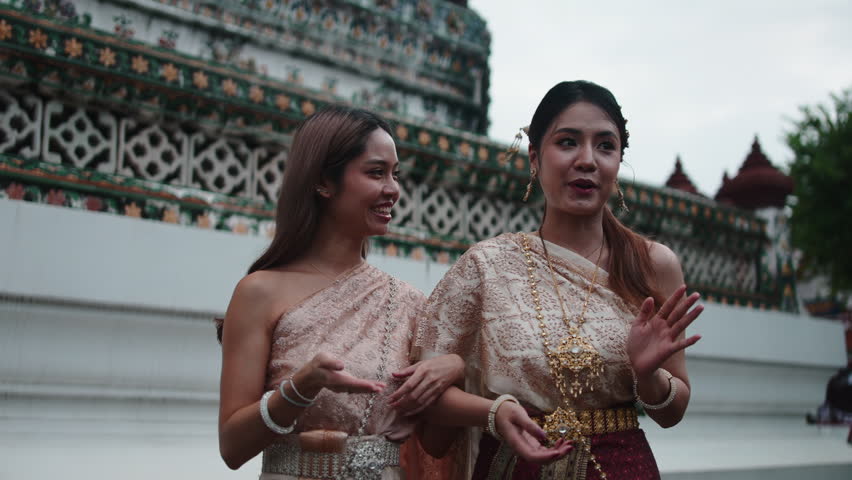 Two thai women in traditional dress at wat arun