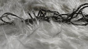 Close-up loop of colorful LED string lights glowing on a soft white fur surface, creating a cozy and festive ambience. Detailed illumination textures enhance the warm decorative atmosphere. - Powered by Shutterstock - Get 15% off with code: PIKWIZARD15