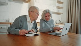 Senior man reading book at home, his wife using smartphone and laptop, leisure. Happy elderly spouses spending weekend together at home, internet addiction and love of reading, surfing internet - Powered by Shutterstock - Get 15% off with code: PIKWIZARD15