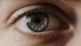 Extreme close-up macro video of a human eye blinking. detailed hazel green iris texture, pupil dilation, and eyelashes. Concept for vision health, biometrics, and optical care. - Powered by Shutterstock - Get 15% off with code: PIKWIZARD15