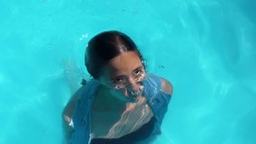 Girl swimming in clear blue water. Young swimmer enjoying a summer pool day. Young woman swimming in refreshing turquoise water. Girl moving through water on a sunny day. Teenager swimming in pool. - Powered by Shutterstock - Get 15% off with code: PIKWIZARD15