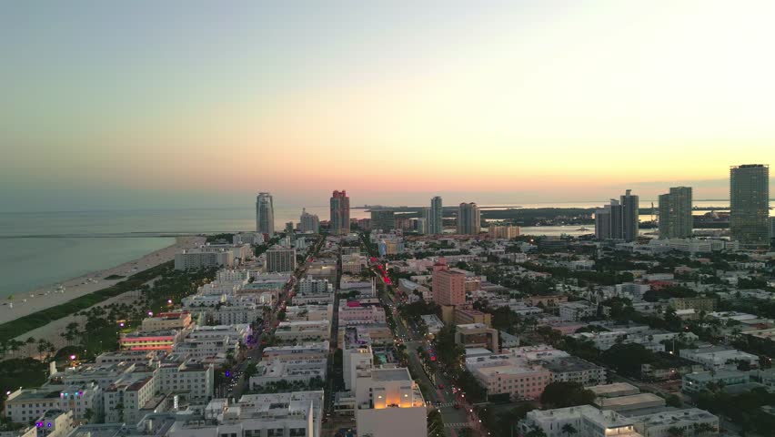 Miami Beach, South Beach at night with dramatic sky. Miami seaside at dusk. Aerial view of evening Miami Beach and cityscape. Coastline of Miami Beach night shot from the air drone.
