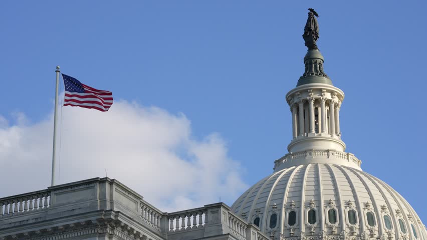Capitol dome with waving US flag. Washington DC government building. Patriotic Capitol scene. Congress landmark architecture. USA federal building view.