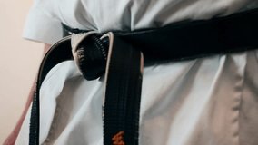 Martial arts expert tying a black belt  - Powered by Shutterstock - Get 15% off with code: PIKWIZARD15