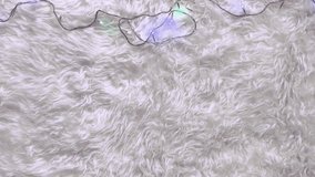 Soft furry background with glowing LED string lights in various vibrant colors looping seamlessly. The fluffy surface, light reflections, and wires create a festive and cozy decorative mood. - Powered by Shutterstock - Get 15% off with code: PIKWIZARD15