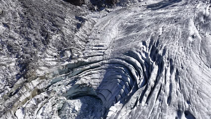 Detailed aerial of deep crevasses and ice folds on Morteratsch Glacier. Graubünden, Switzerland