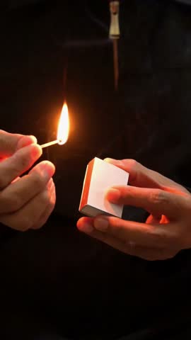 hand lighting a match in close up