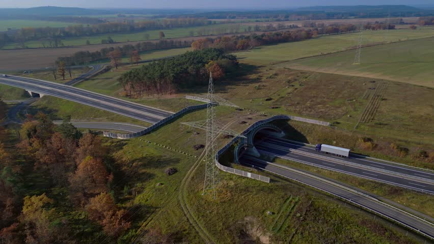 Ecoduct providing safe passage for wildlife over a german autobahn highway, seen from above. Breathtaking aerial view flight panorama orbit drone