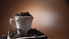 A white cup overflowing with coffee beans rotates on a saucer against a soft brown background. Elegant minimal coffee concept. - Powered by Shutterstock - Get 15% off with code: PIKWIZARD15