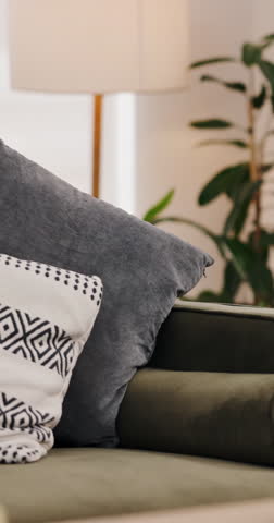 Empty, living room and sofa with cushions in home for interior design, decoration and aesthetic. Minimal seating, apartment and fabric pillows on couch for comfort, elegant style and cozy residence