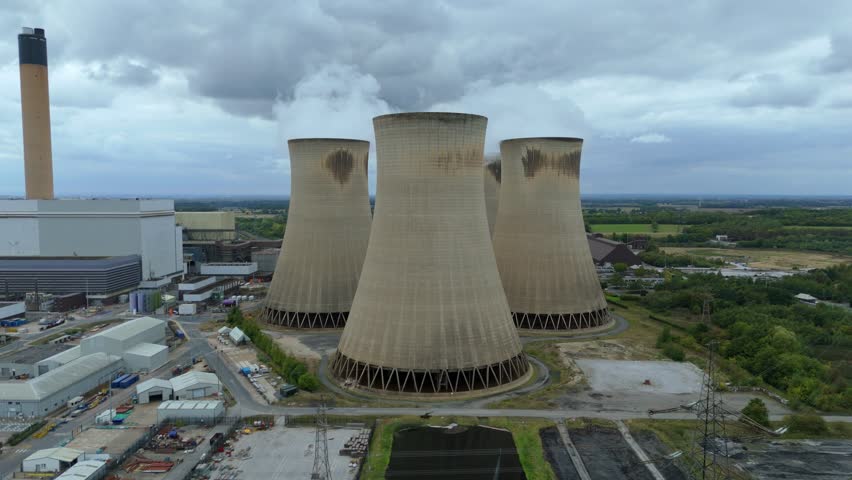 Aerial drone view of Huge power plant with colling towers and smoke plumes billowing, industrial energy electrical generation coal gas and oil near Selby, Yorkshire, United Kingdom