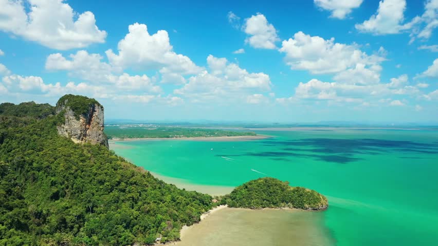 Aerial view of tropical island coastline with turquoise water and blue sky above