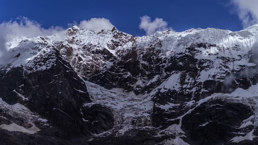 Mount Humantay Peruvian Andes Mountain Range Peru Perú time lapse laguna Humantay weather fog clouds movement blue skies snow capped glacial peaks Sulcantay Trek high altitude elevation static shot