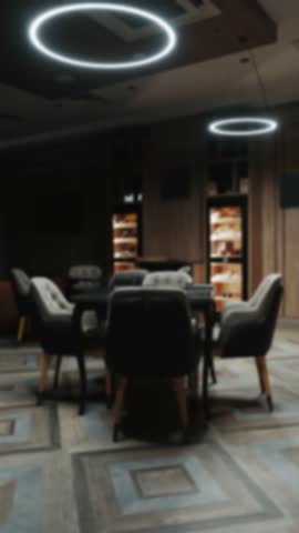 Blurred background of modern interior with elegant chairs, table, and glowing circular lights in lobby room